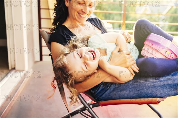 Caucasian mother and daughter playing on patio