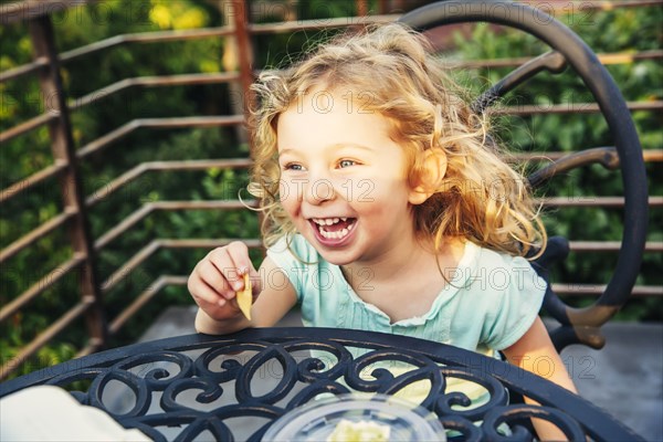 Caucasian girl eating on patio