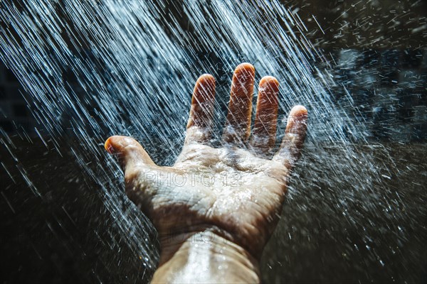 Caucasian man rinsing hand under water