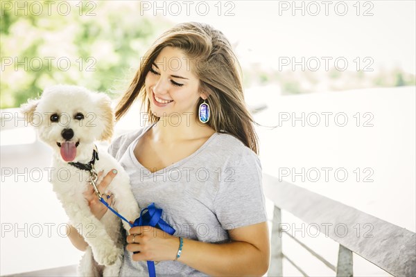 Caucasian woman carrying dog outdoors