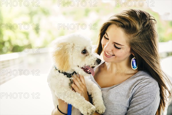 Caucasian woman carrying dog outdoors