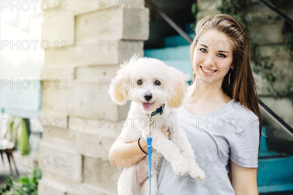 Caucasian woman carrying dog outdoors