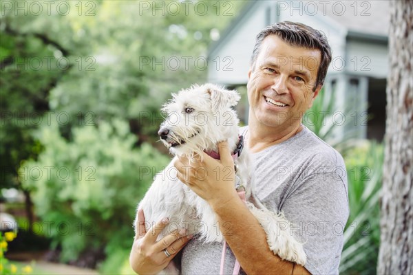 Caucasian man petting dog outdoors