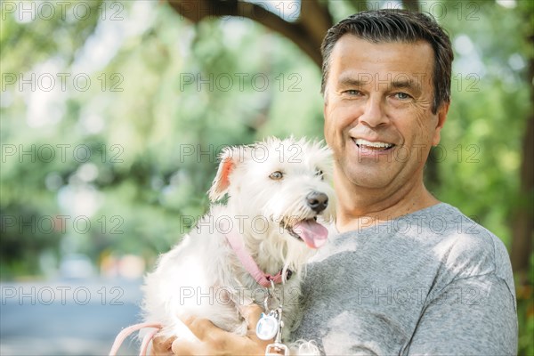 Caucasian man petting dog outdoors