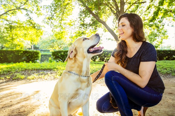 Caucasian woman petting dog outdoors