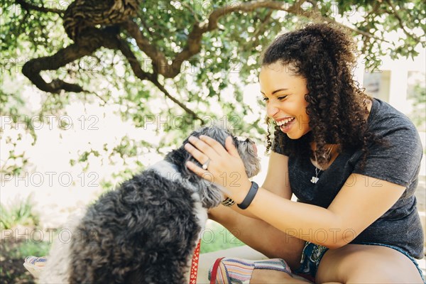 Black woman petting dog outdoors