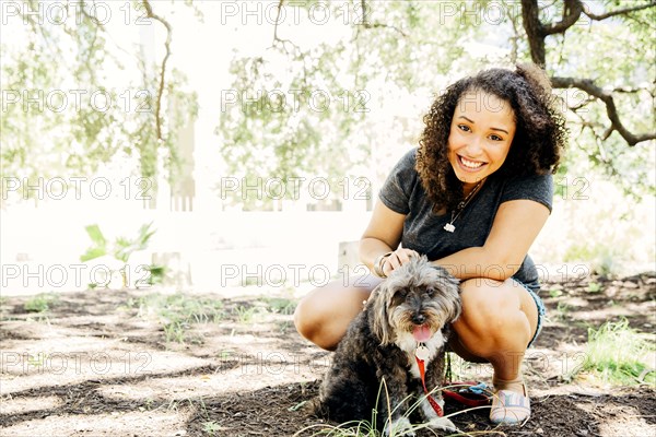 Black woman petting dog outdoors