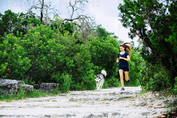 Caucasian woman jogging with dog