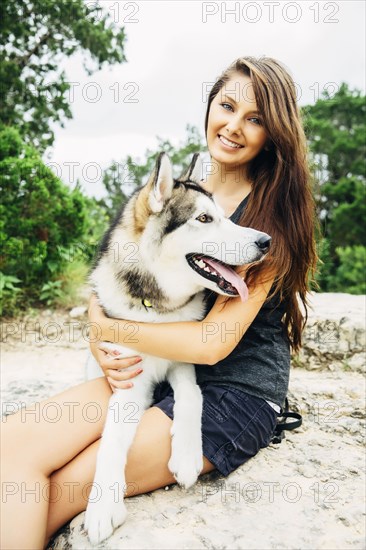 Caucasian woman petting dog outdoors