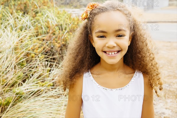 Mixed race girl smiling on beach