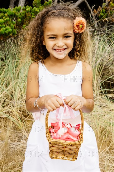 Mixed race girl carrying flower basket