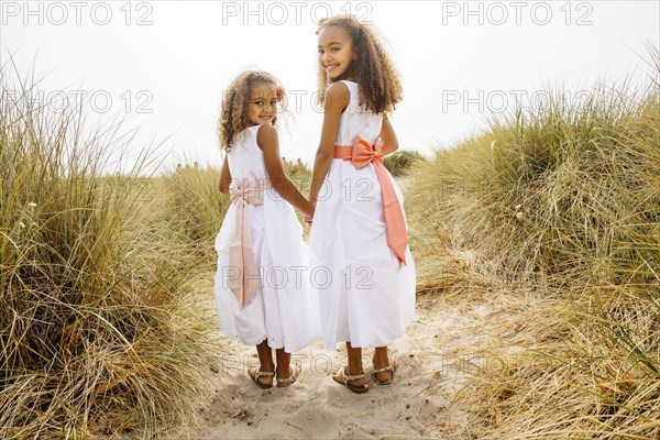 Mixed race sisters walking on beach