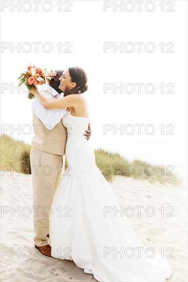 Bride and groom hugging in outdoor wedding