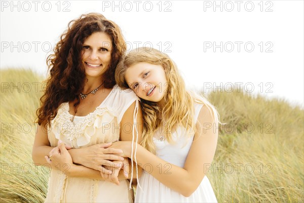 Mother and daughter smiling on beach