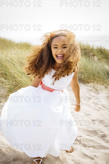 Mixed race girl laughing on beach