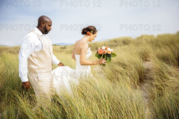 Newlywed couple walking on beach