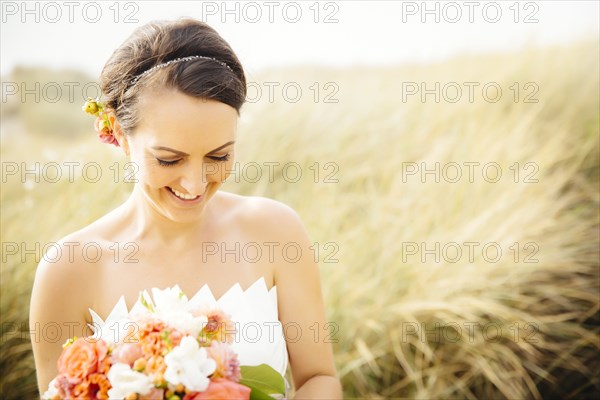 Caucasian bride standing in grass