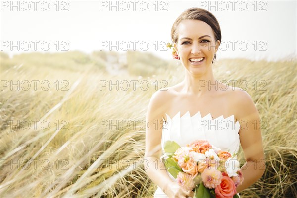 Caucasian bride standing in grass