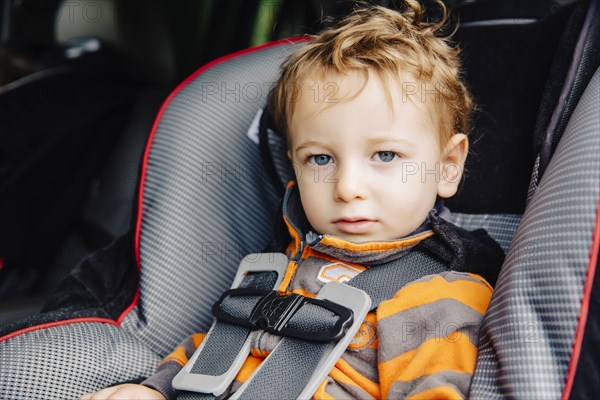 Caucasian boy sitting in car seat