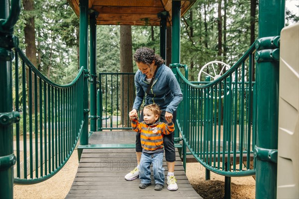 Caucasian mother and son playing on playground