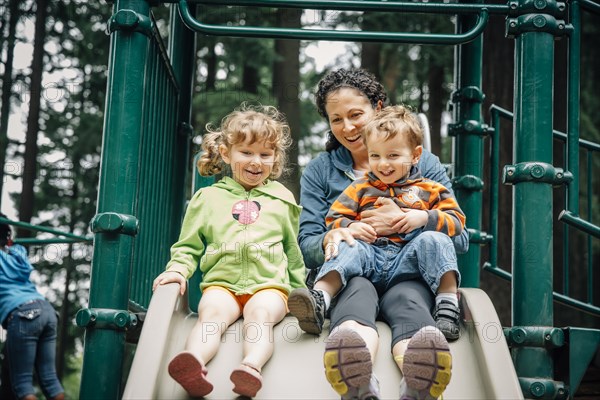 Caucasian mother and children playing on playground