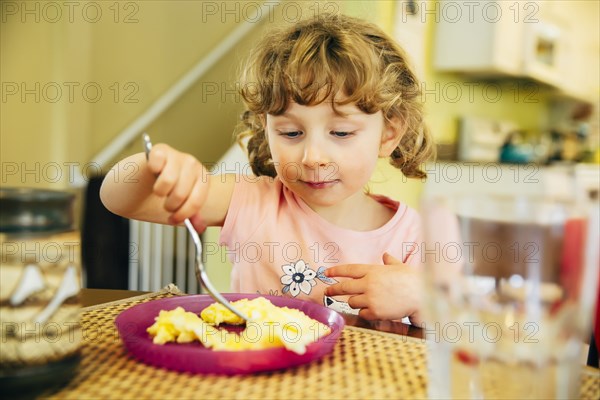 Caucasian girl eating at table