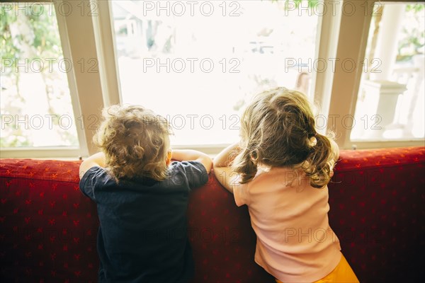 Caucasian children standing on sofa