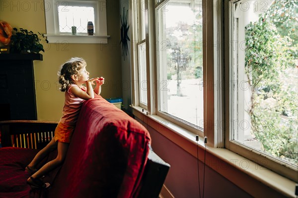 Caucasian girl looking out window