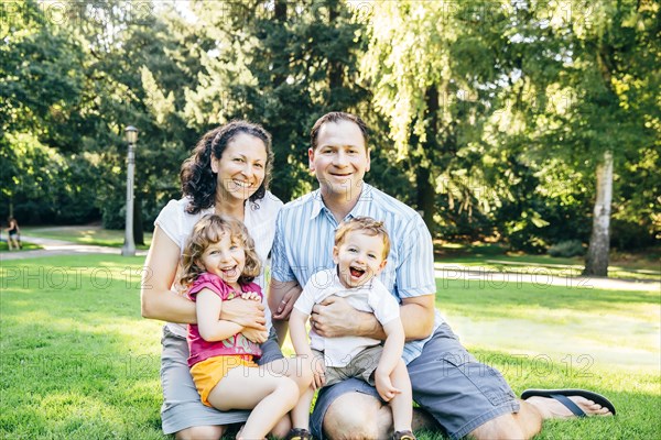 Caucasian family sitting in park