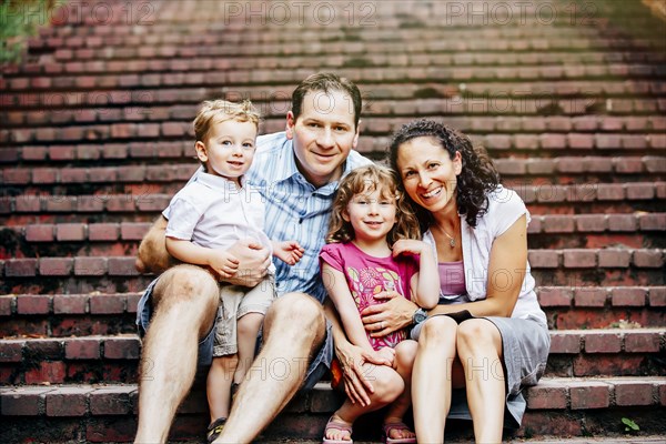 Caucasian family sitting on steps