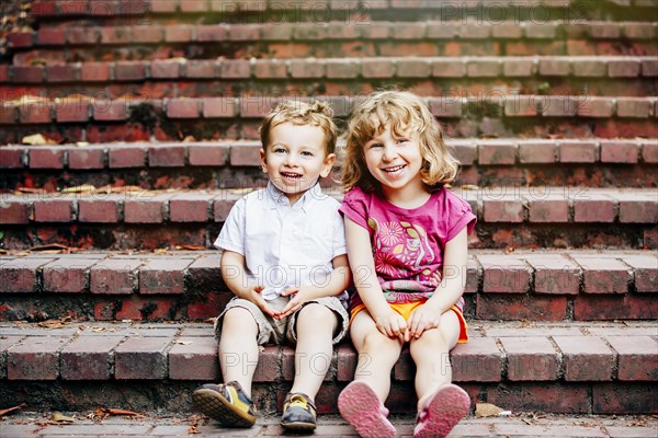 Caucasian children sitting on steps