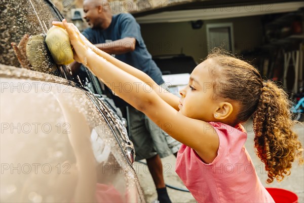 Father and daughter washing car