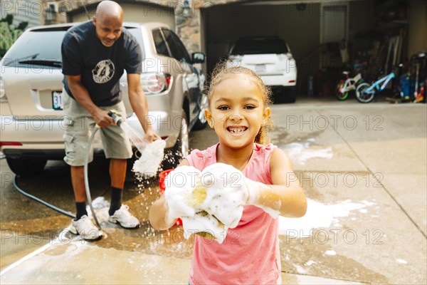 Father and daughter washing car
