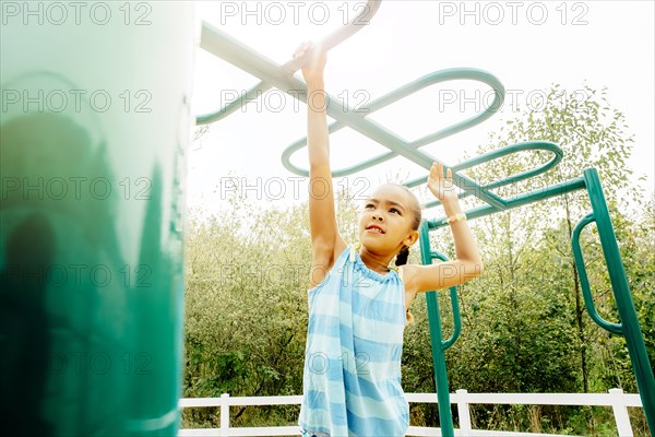 Mixed race girl playing on playground