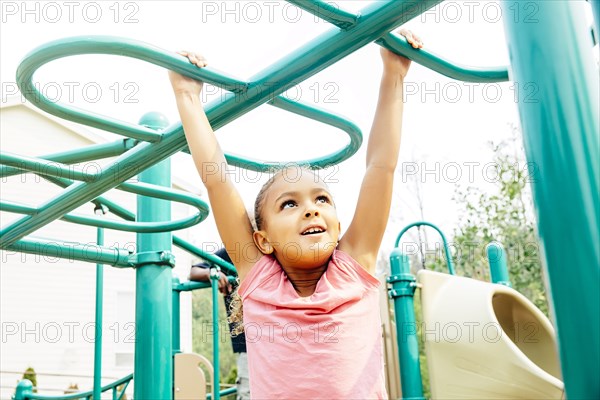 Mixed race girl playing on playground