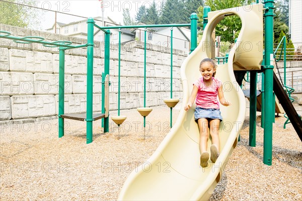 Mixed race girl playing on playground