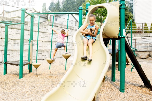 Mixed race sisters playing on playground