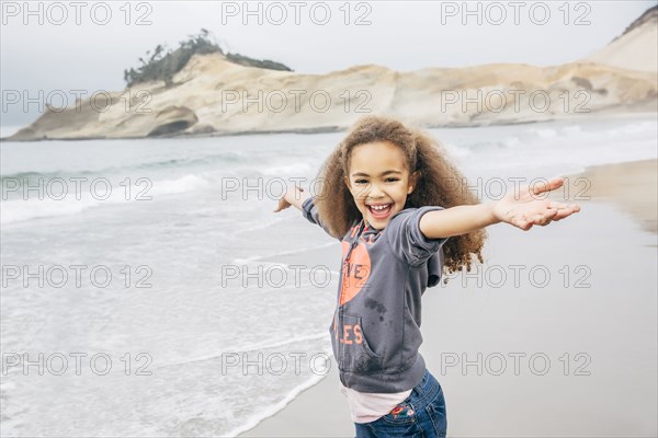 Mixed race girl playing on beach