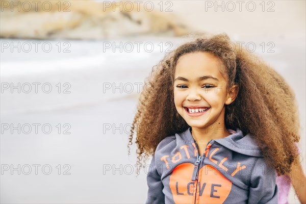 Mixed race girl smiling on beach