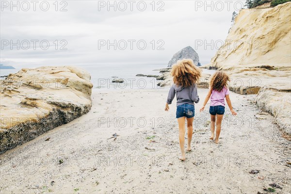 Mixed race sisters walking on beach