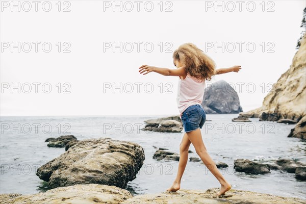 Mixed race girl walking on beach