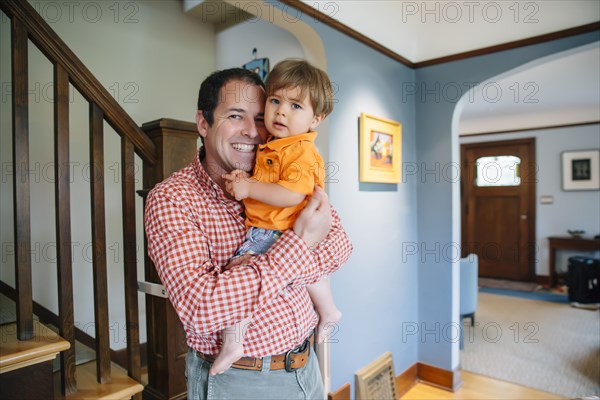 Father holding son at staircase