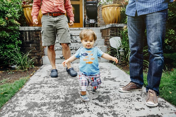 Gay fathers and baby son standing outdoors