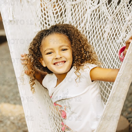 Mixed race girl sitting in hammock