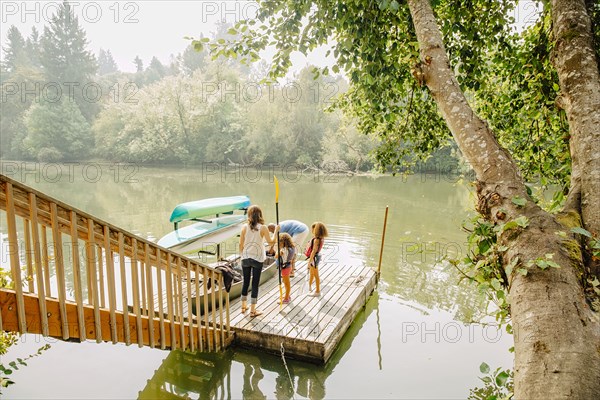 Family standing on dock in lake