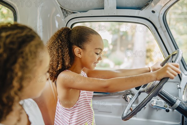 Mixed race sisters driving in car