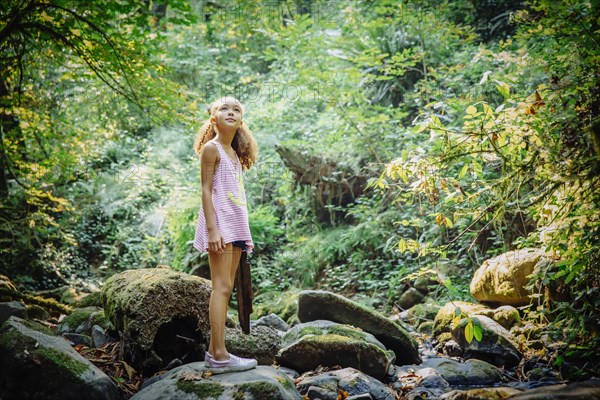 Mixed race girl exploring stream