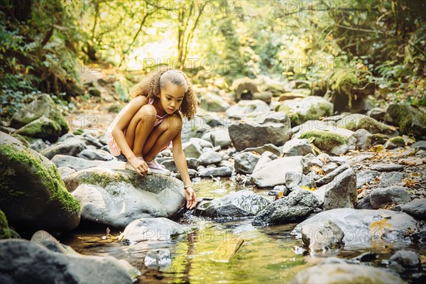 Mixed race girl exploring stream