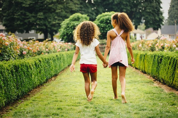 Mixed race sisters walking in garden