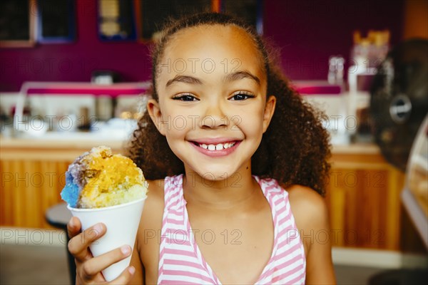 Mixed race girl holding snow cone